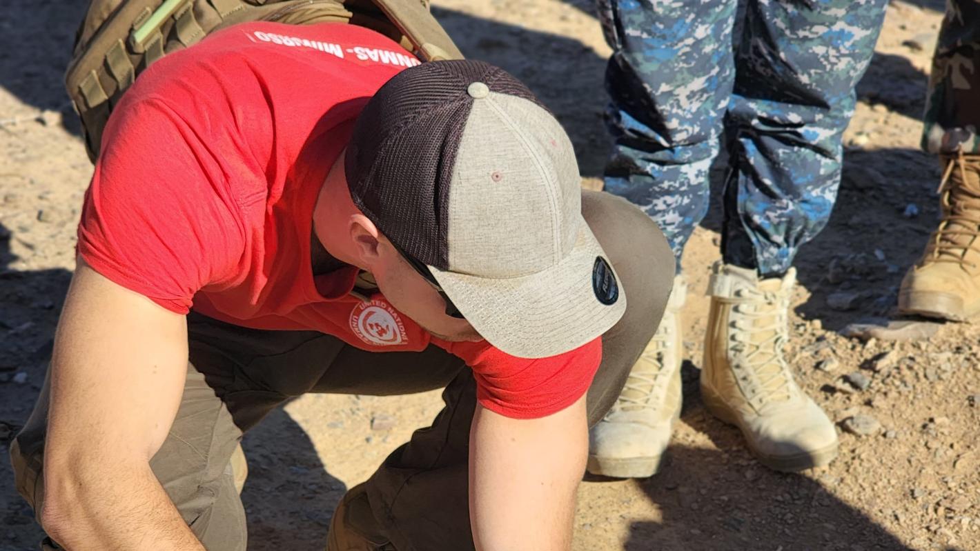 a man is measuring the with of a hole on the ground