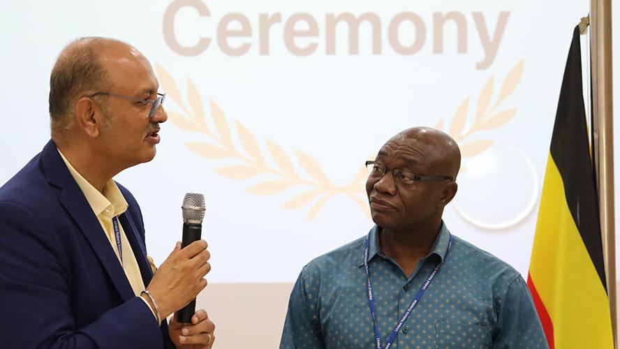 Chief FSDH, Sanjay Khanna (l) delivers his appreciation of James Nsoh's (r) dedication and work ethic.