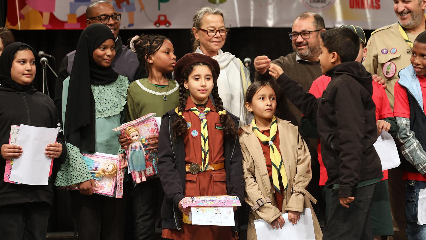 Children and men standing next to DSRSG-RC