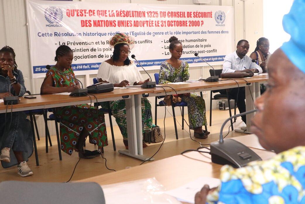 A conference panel addresses an audience.