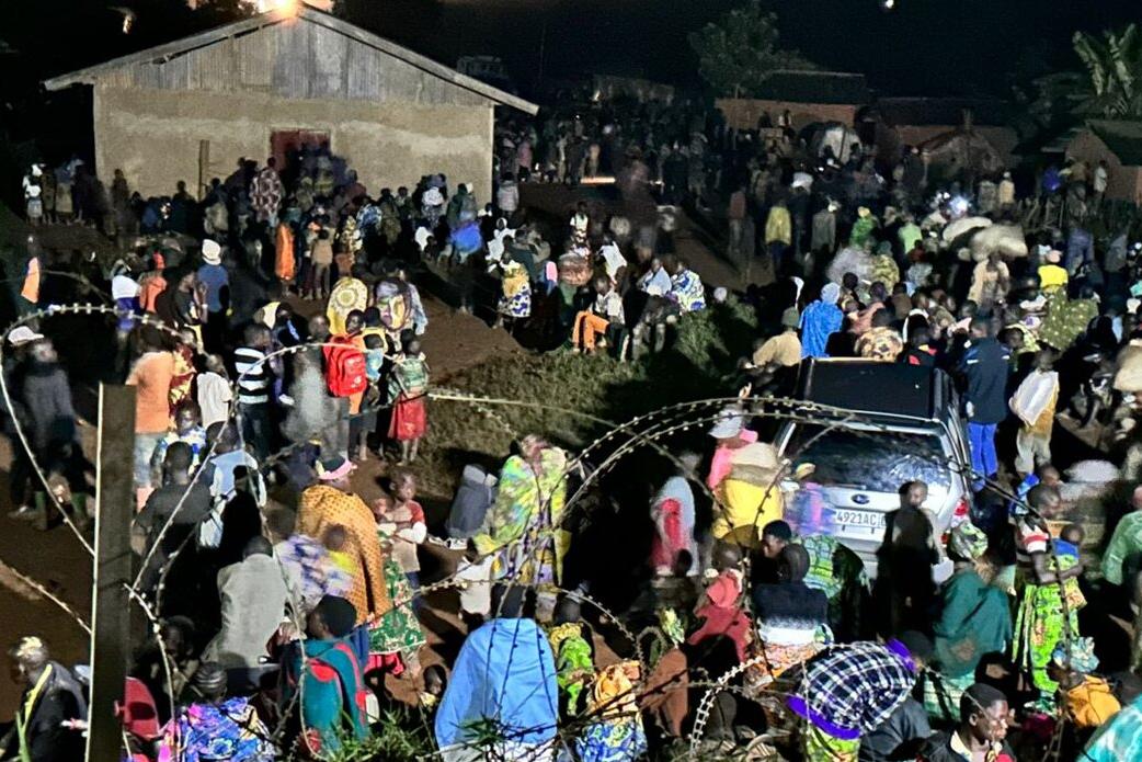 Un groupe de personnes se tient à l'extérieur.