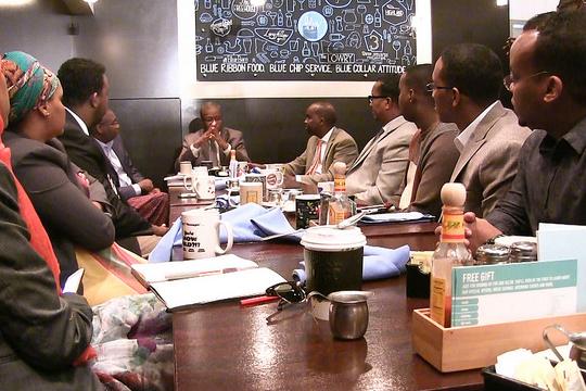 A group of men and women sit around a table